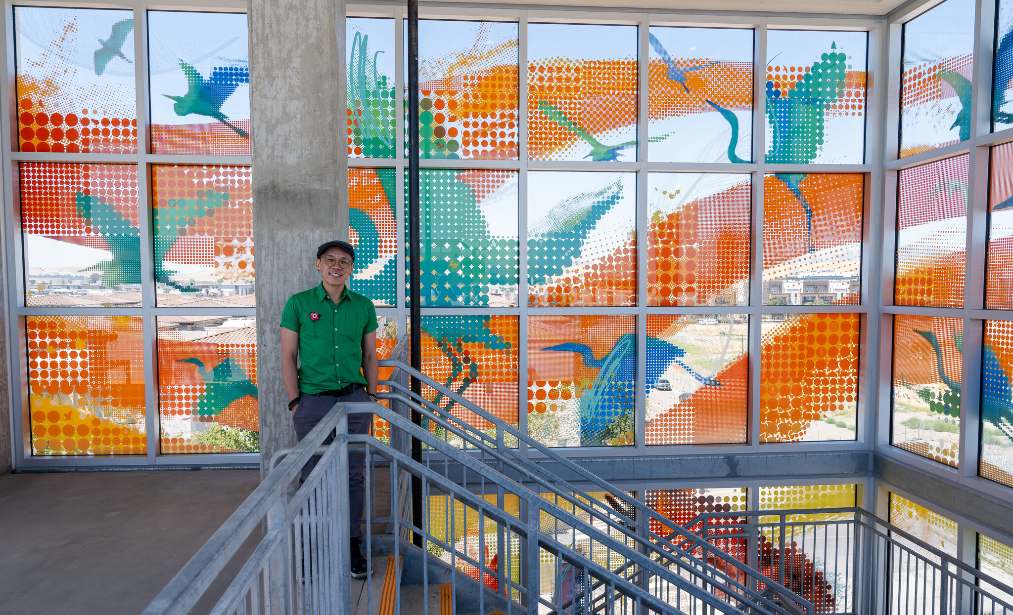 Dublin Transit Center Art Dedication-49 Artist Phillip Hua standing in front of his artwork design on the 5th floor of the Dublin Transit Center Parking Garage. Photo by Ryan Moran.